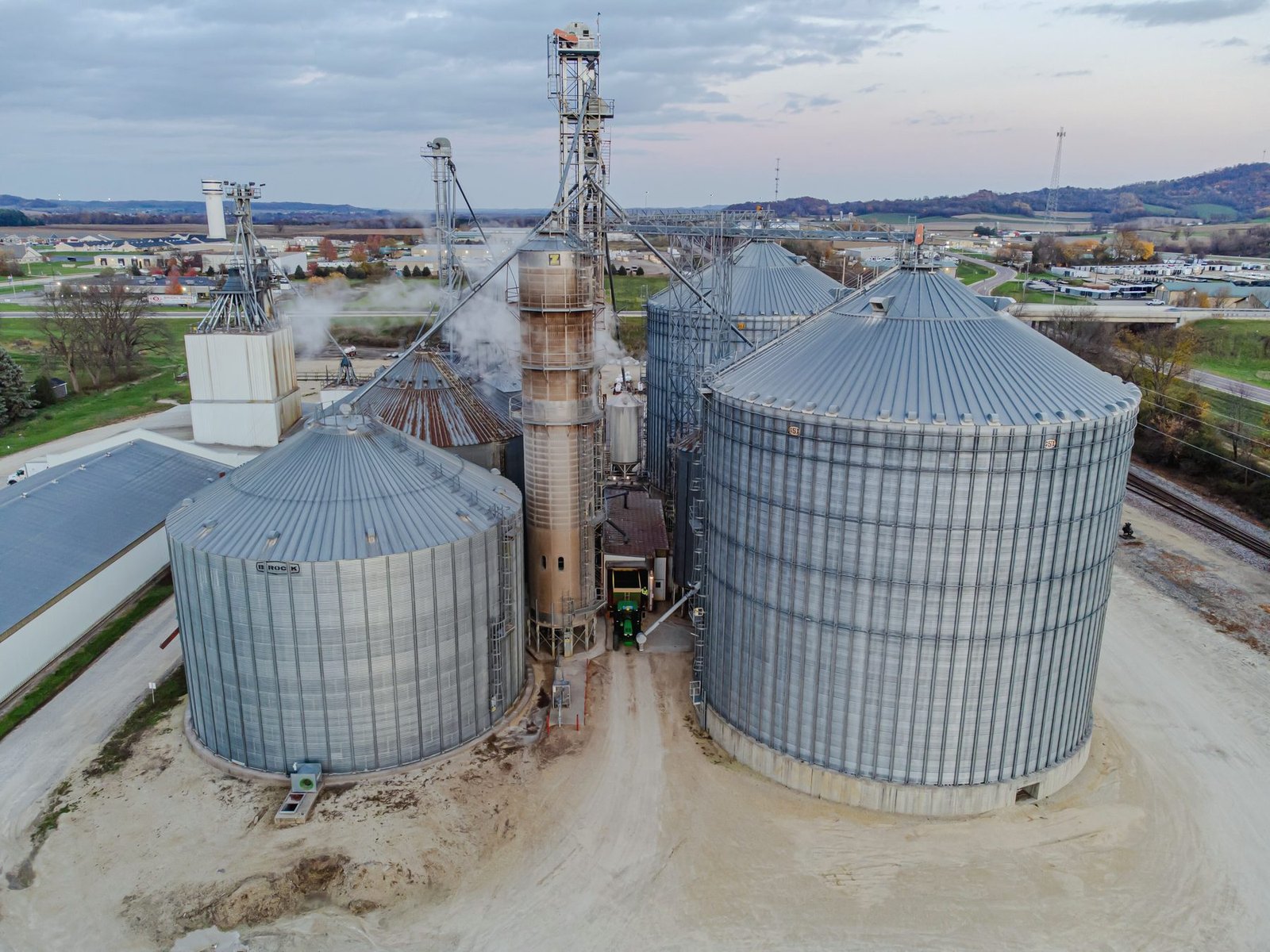 Steel grain bins beside a tall column grain dryer, seen from above