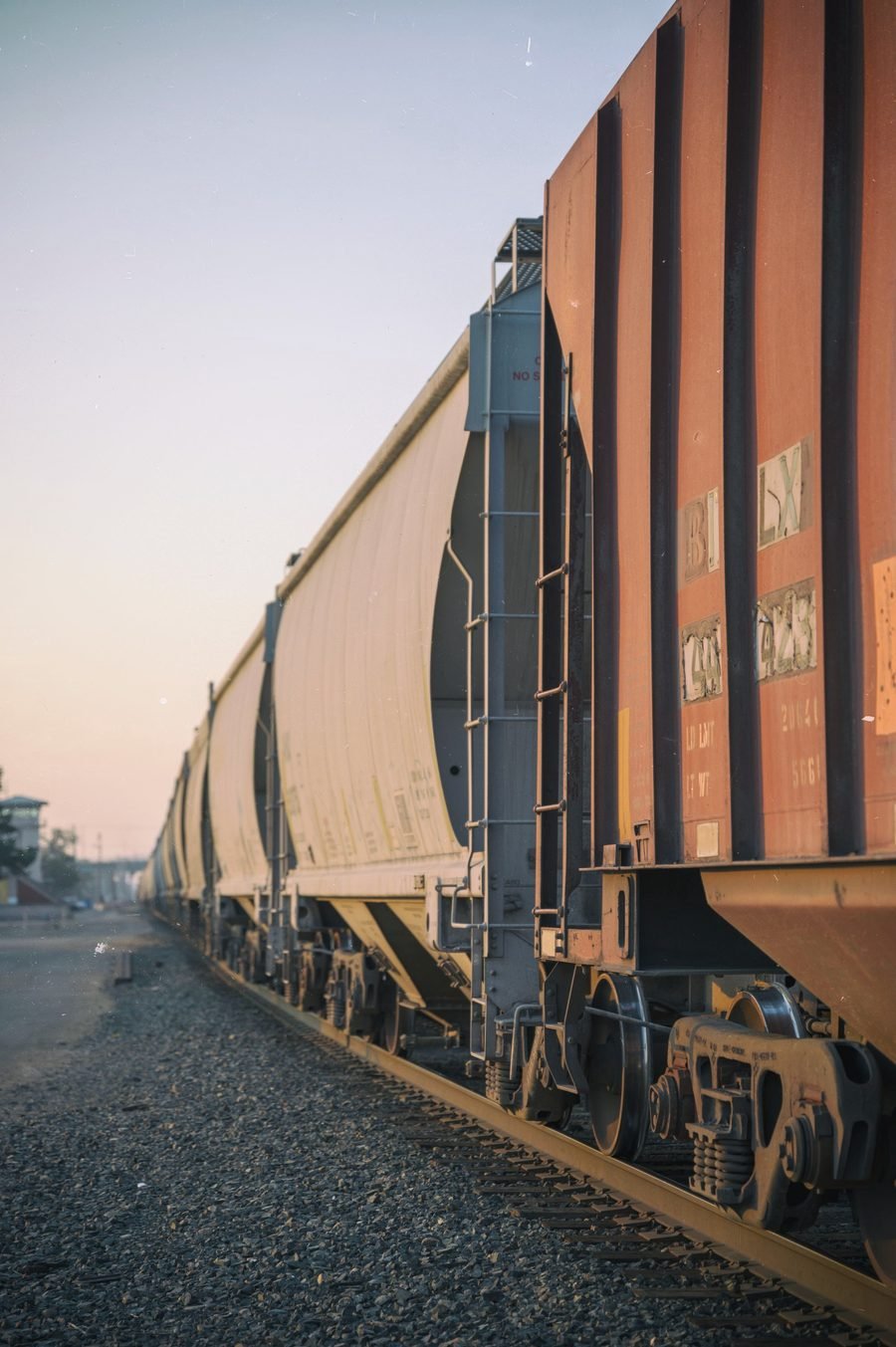 Hopper cars lined up on a track at dusk